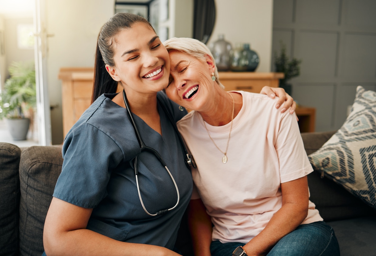image (2) Senior woman hugs home nurse in house living room in comfort trust, support or security bond. Smile, happy or laughing nursing home retirement elderly and healthcare Brazilian nurse or help